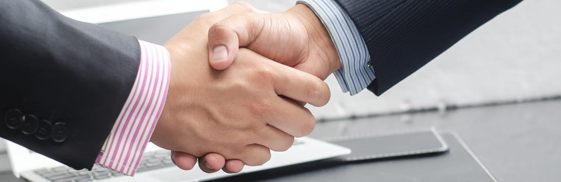 Handshake between two professionals in business attire.
